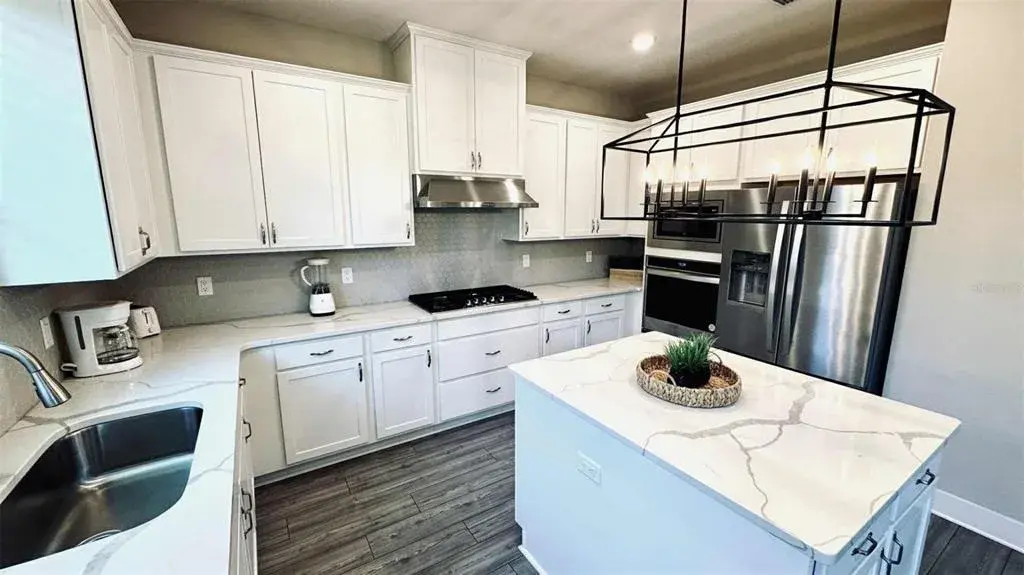 Modern kitchen with granite countertops, stainless-steel appliances, and large island ideal for gatherings.