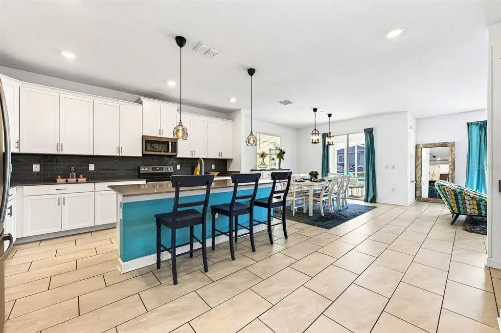 The spacious Kitchen is both stylish and functional, featuring 42-inch white cabinetry, QUARTZ COUNTERTOPS, a closet pantry, STAINLESS STEEL APPLIANCES and a sleek backsplash.