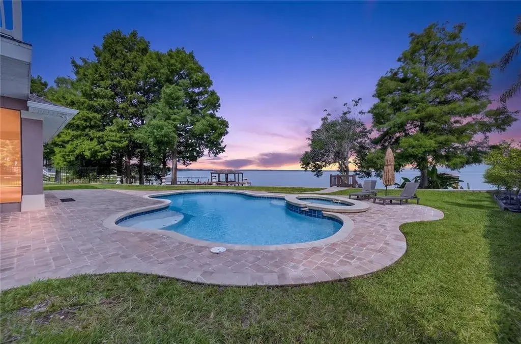 Amazing sunsets from the incredible outdoor living space with well designed heated pool and raised spa, lounging area and dock