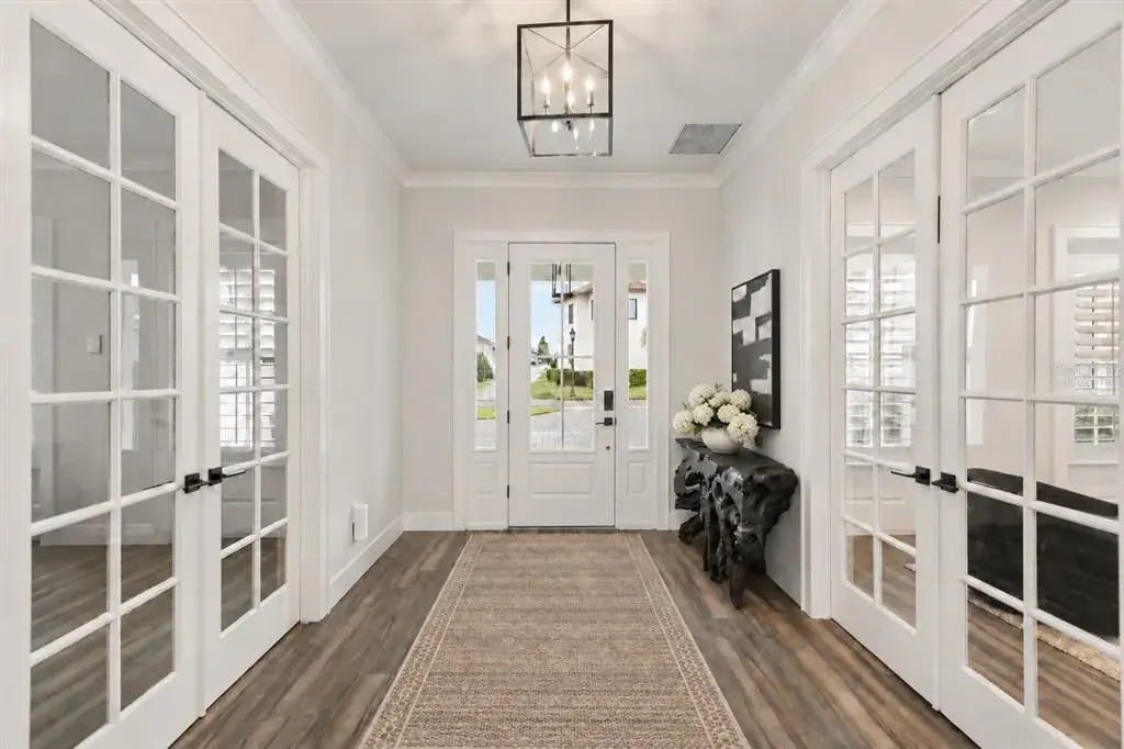 INDOOR-OUTDOOR LIVINGAn open living area extends toward the kitchen and expansive sliding glass doors, bringing the screened porch and conservation landscape into view.