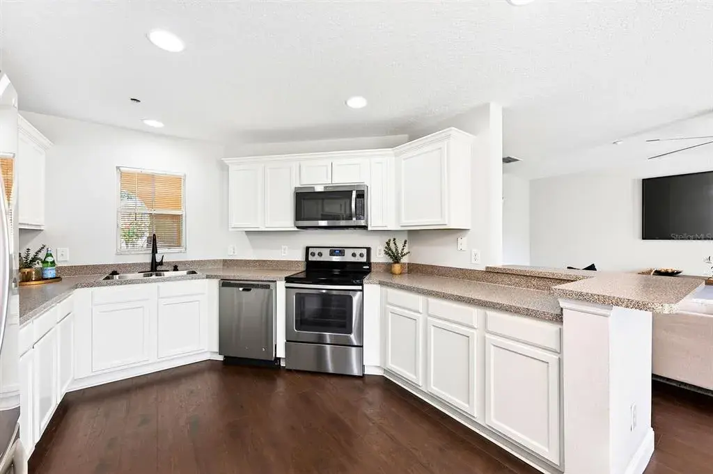 The light, bright open kitchen delivers ample cabinet and counter space, stainless steel appliances, and a breakfast bar for casual dining or entertaining.