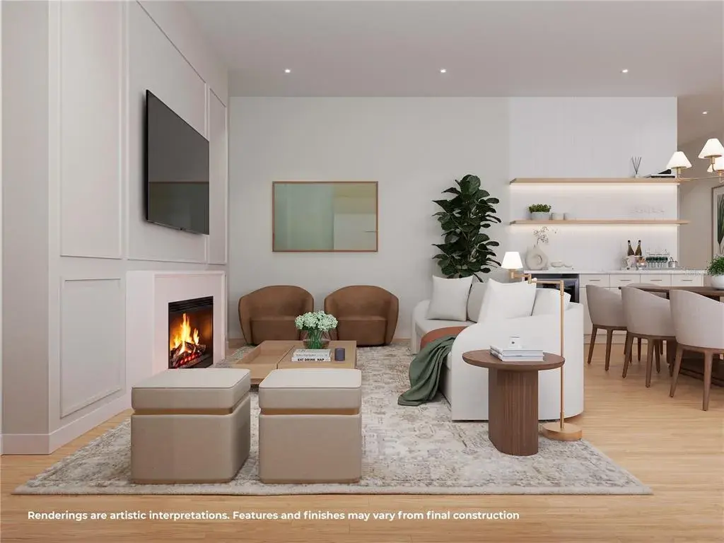 Bright, open-concept great room featuring a fireplace, abundant natural light and seamless flow into the kitchen and dining areas
