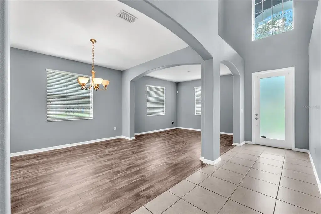 A two-story foyer with a soaring 19-foot ceiling and leaded glass front door creates an impressive first impression.