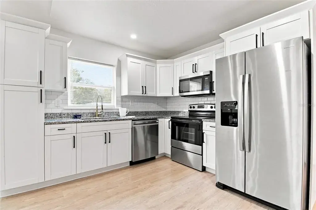 Your gleaming kitchen includes Shaker style, soft close cabinets, black and white mottled marble countertops and all stainless steel appliances and sink