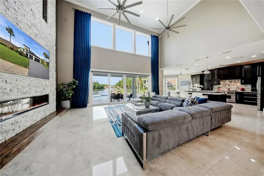 Family room with floor to ceiling stone fireplace with porcelain tile floors