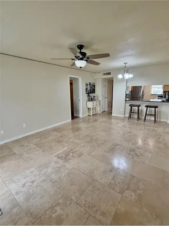 The living room is 20x12 and features travertine floors and a lighted ceiling fan.