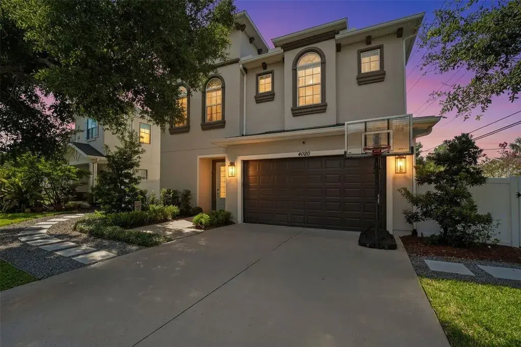 Stunning two-story façade highlighted by arched windows, elegant trim details, and warm evening lighting for inviting curb appeal.