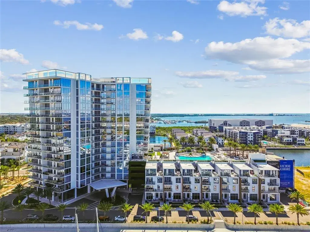 Community & Surroundings – Contemporary waterfront high-rise with resort-style pool deck, palm-lined streets, and immediate access to the marina district.