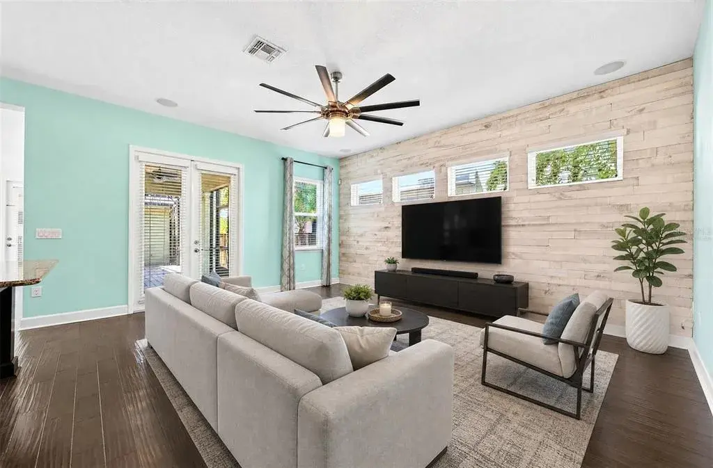 A custom accent wall adds personality to the living room. Virtually Staged.
