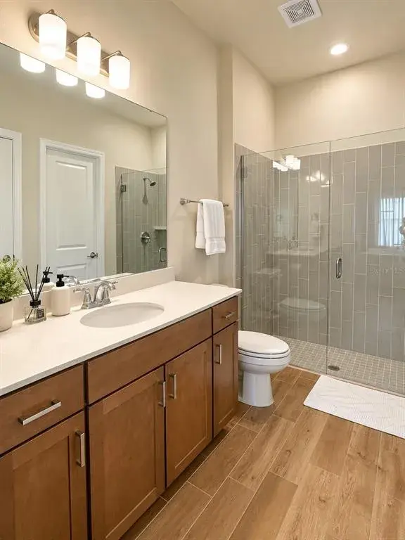 Guest Suite Bathroom – Private in-suite bathroom featuring a spacious walk-in shower with glass enclosure, modern vanity, and contemporary finishes.
