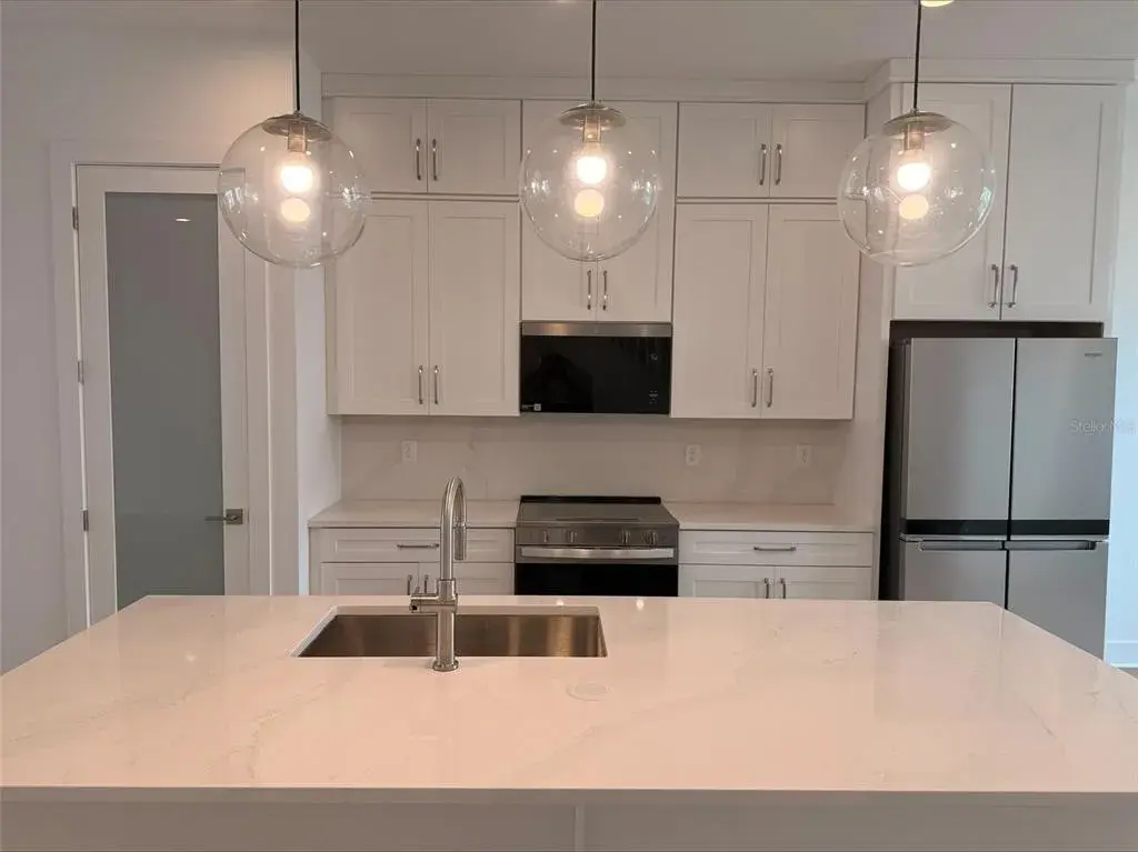 Kitchen with full appliance package, quartz countertops and backsplash, double stacked cabinets