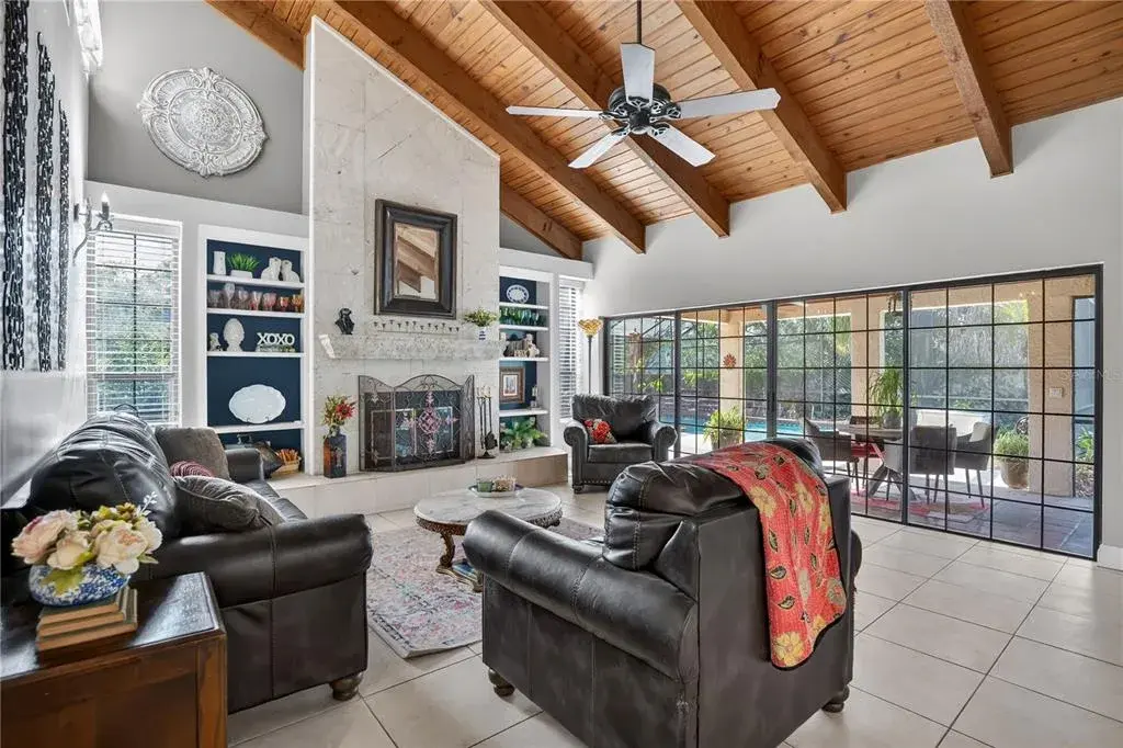 The great room with exposed wood beams and wood-burning fireplace