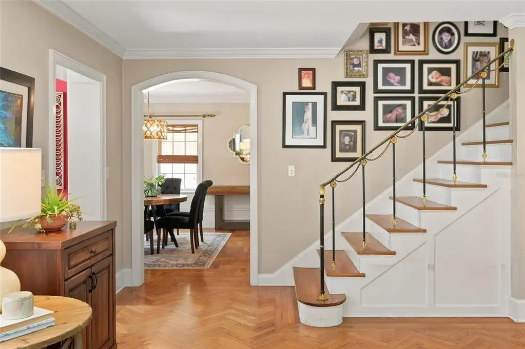 Welcoming Foyer with Hardwood Floors, Custom Railing, Arched Doorways and Extensive Millwork.