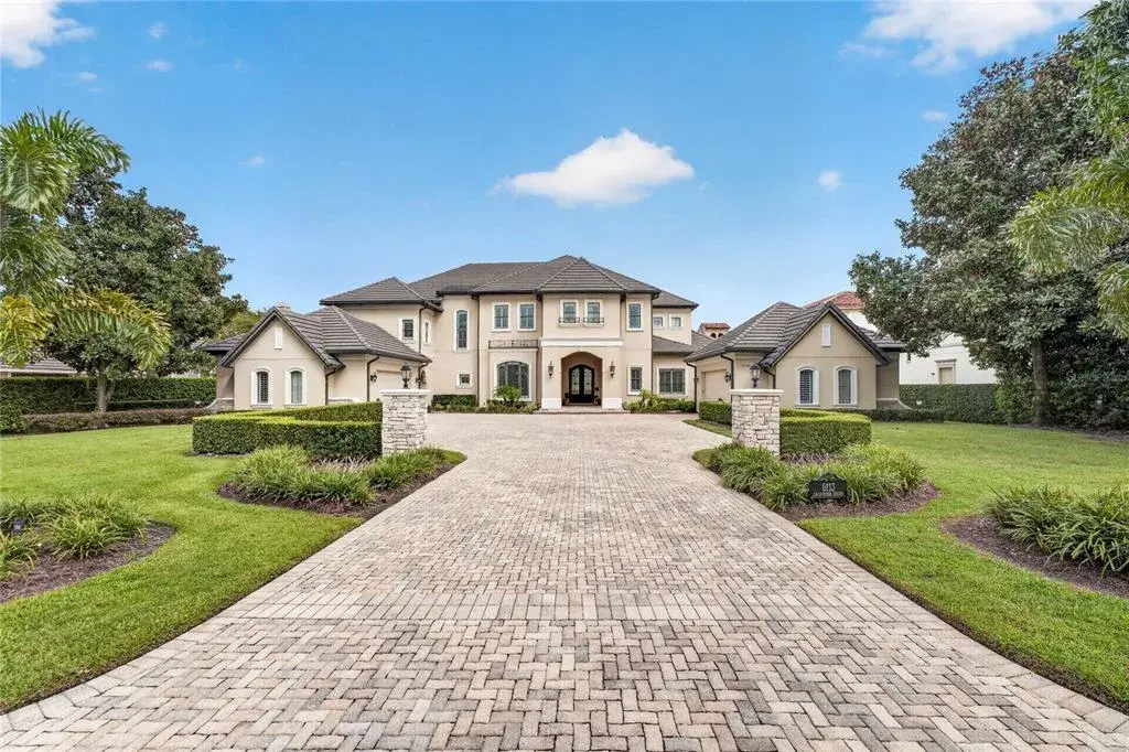 Exterior View. This home offers an extended paver drive with side parking pads and twin motor courts for garage parking for 4 vehicles + left side entry golf cart garage.
