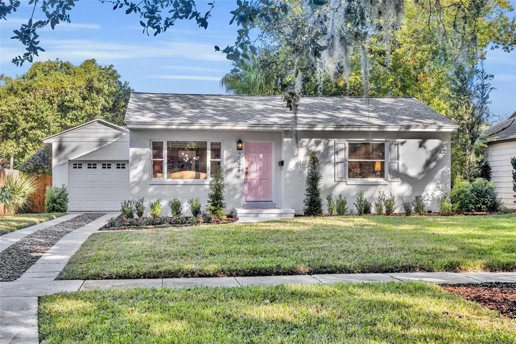 Front elevation showcasing the exterior, landscaping, and charming pink front door.