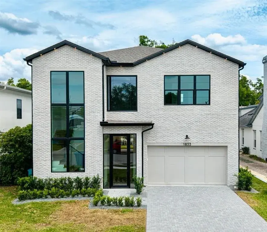Front exterior showcasing a blend of brick and smooth stucco architecture with modern lines and professional landscaping.