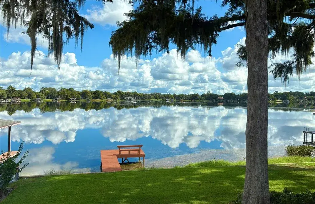 LAKE SUE framed by graceful trees and breathtaking reflections across the tranquil waters of Lake Sue, this extraordinary waterfront setting captures the timeless beauty of Central Florida lakefront living.