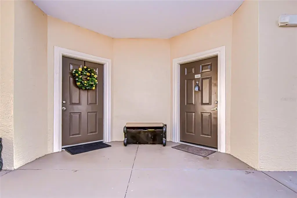 Welcoming exterior entry features dual front doors and neutral tones, providing a covered entryway and easy access into the home.