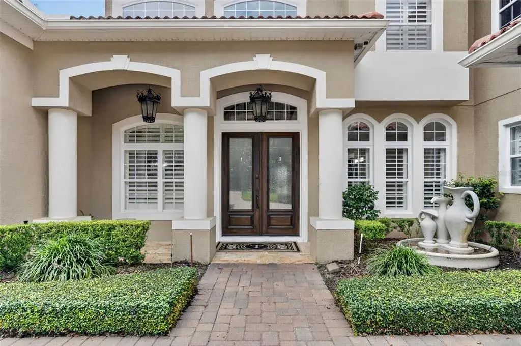 Covered front entry with double doors and distinctive architectural detailing.