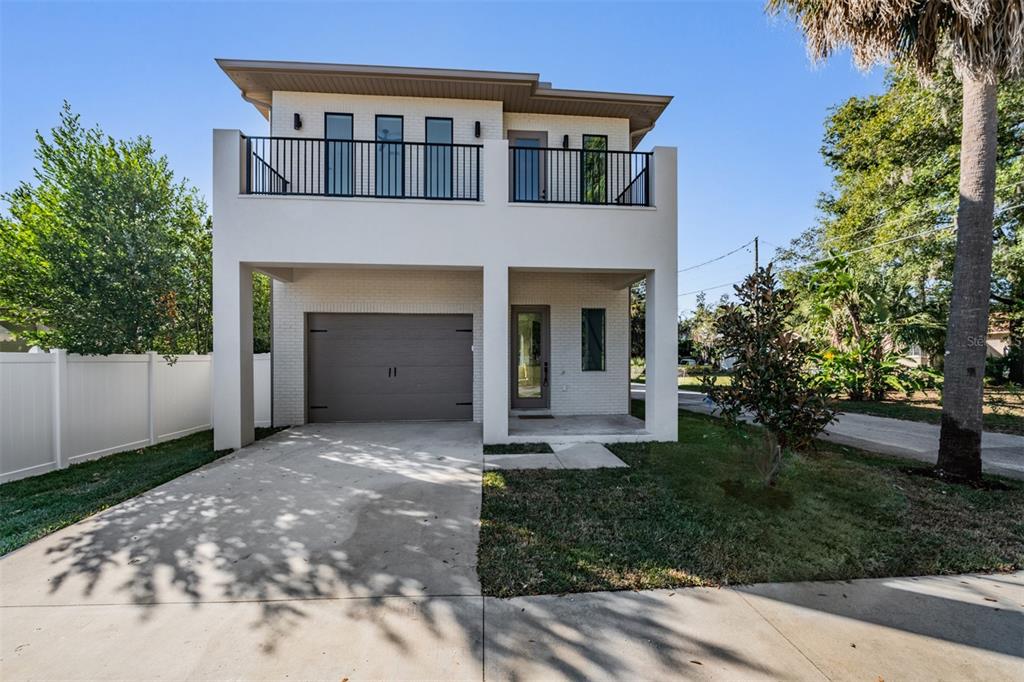 Sleek modern facade with covered entry and balcony