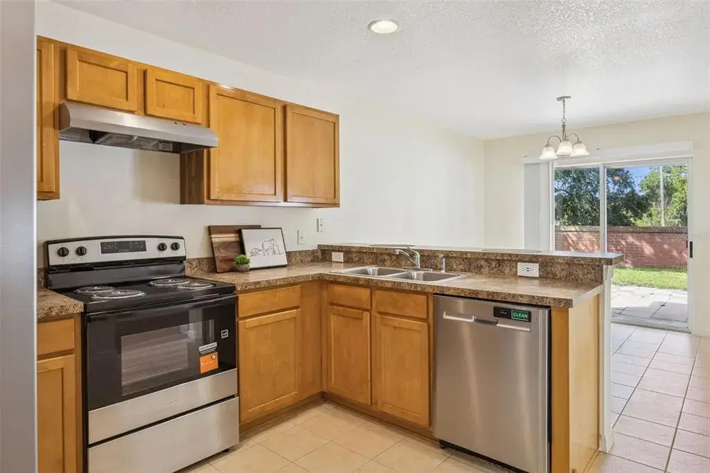 Kitchen with new range and range hood, open to the breakfast nook