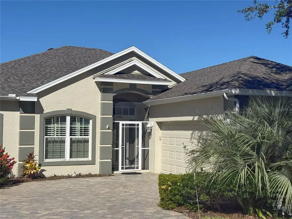 Front exterior of home with pavers driveway, screened in front porch, gutters, bevel glass front door with side windows