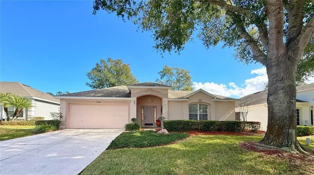 Front exterior of home with gutters and mature landscaping