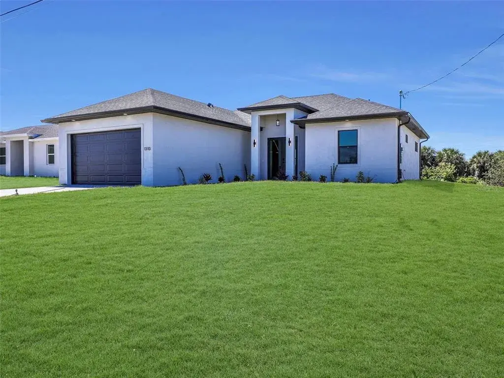 Contemporary stucco exterior with dark trimaccents the color of the grass has been virtually enhanced