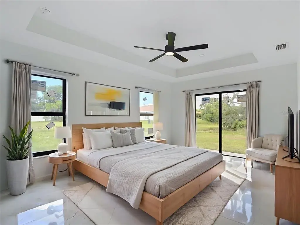 Staged primary bedroom with sliders onto the backyard.