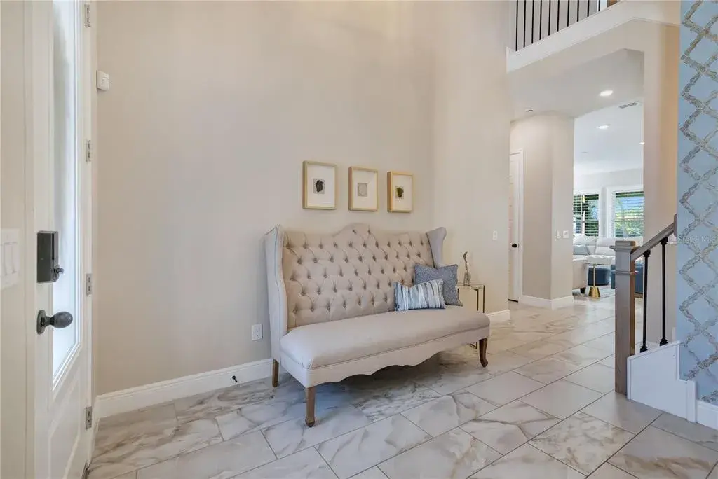 Bright foyer with soaring ceilings and upgraded tile flooring creates an inviting first impression.