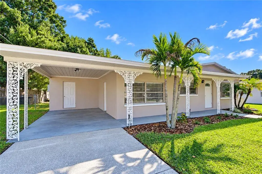 Front exterior view showcasing the well-maintained curb appeal, driveway, and mature landscaping of the property.