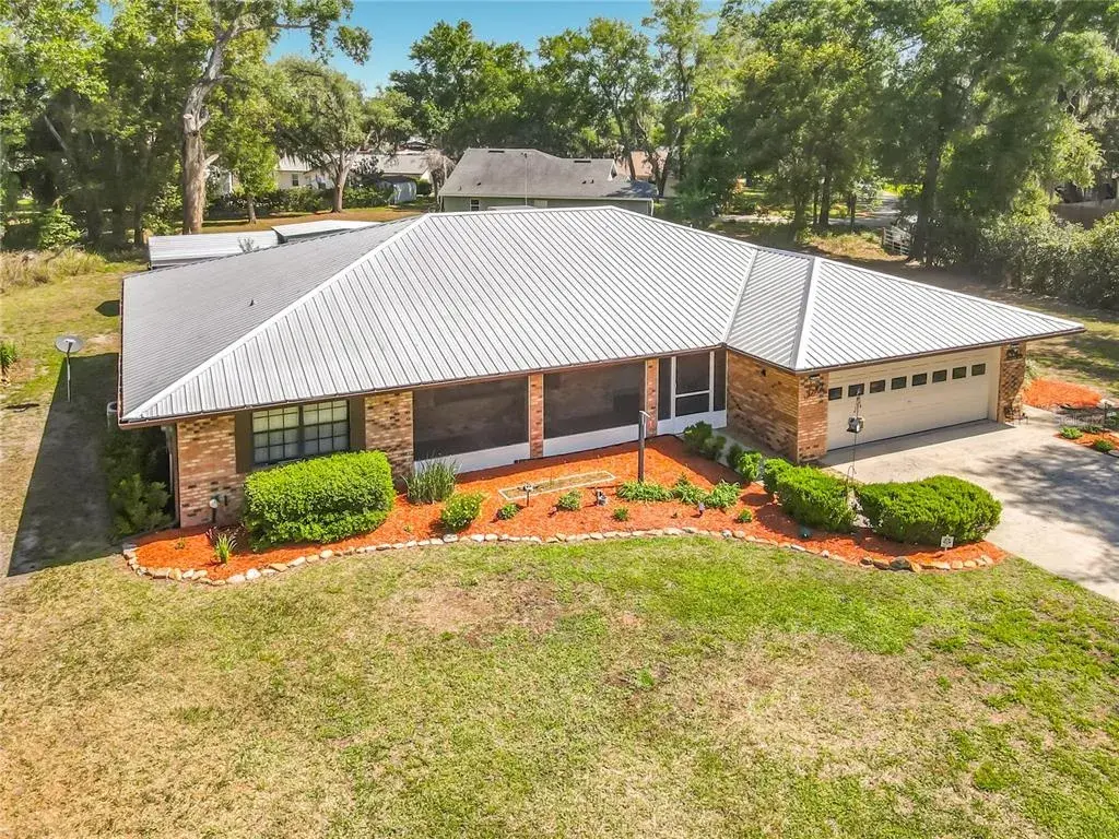 Exterior front view features, newer metal roof, two car garage, screened covered front porch and decorative shutters.
