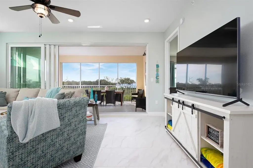 open floor plan, with wall to wall slider to screened in Lanai and waterfront bay and sunset views