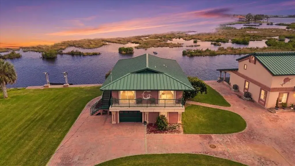 Twilight aerial showcasing the waterfront residence and natural coastal setting.