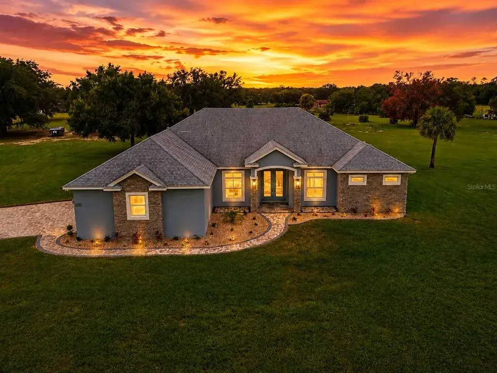 Exterior front of home. Situated on Just under 5 acres of land, brick paver drive, and heated salt water screen enclosed swimming pool.