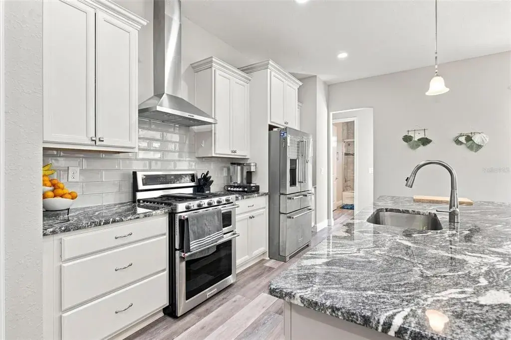Open floor plan features kitchen overlooking Living Room featuring granite countertops and stainless steel appliances.