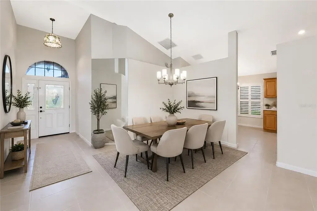 Virtual staged. Cathedral ceiling over foyer and dining.