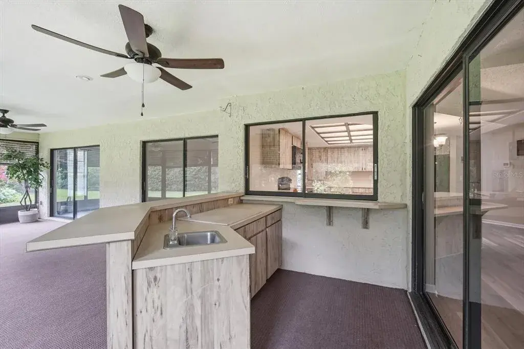 Massive outdoor covered, screened lanai with outdoor kitchen and ceiling fans