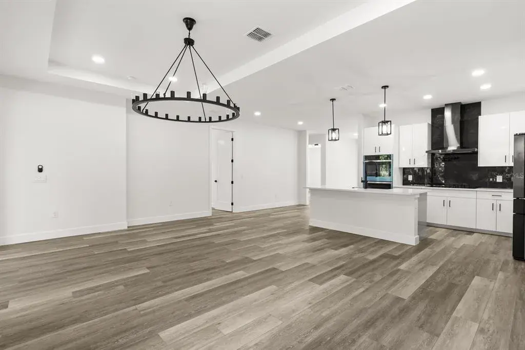 Bright, open-concept living area with vaulted ceilings and luxury vinyl plank flooring.