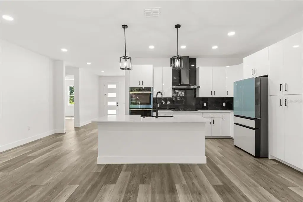 Modern kitchen featuring quartz countertops, shaker-style cabinetry, and stainless steel appliances.