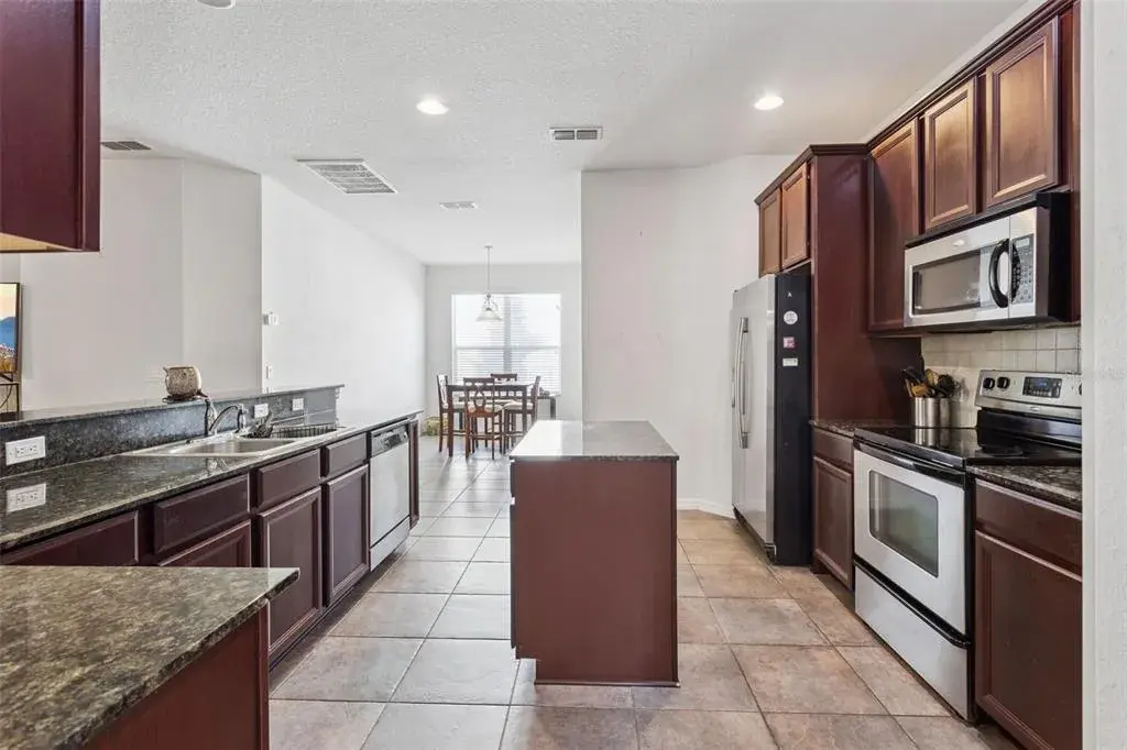 Kitchen featuring granite countertops, center island, and open sightlines to living area