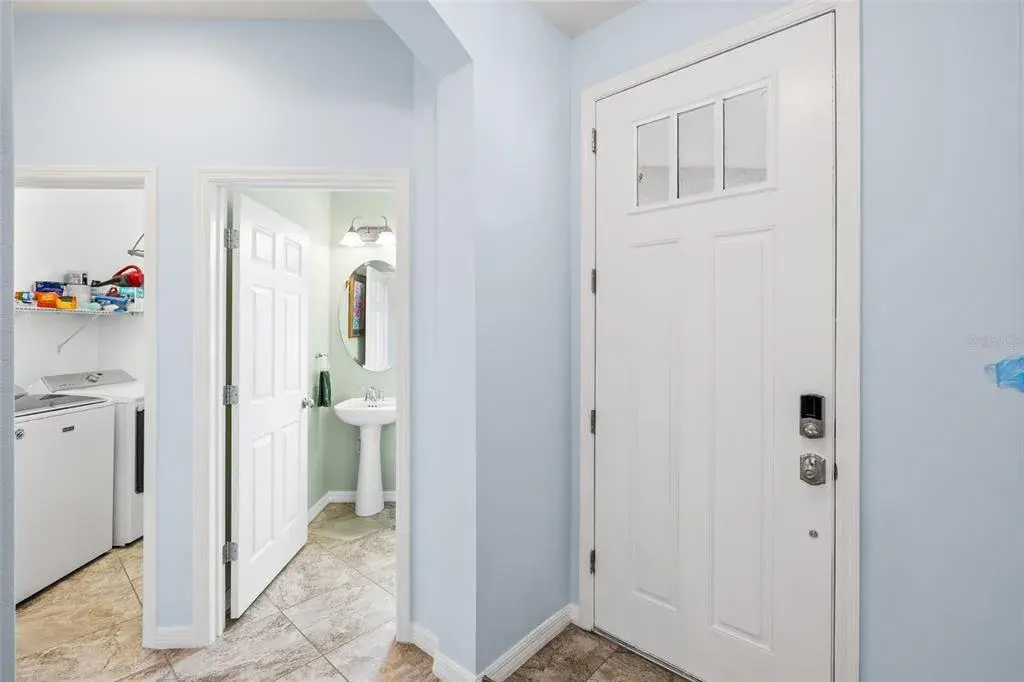 Foyer looking toward half bath and interior laundry room