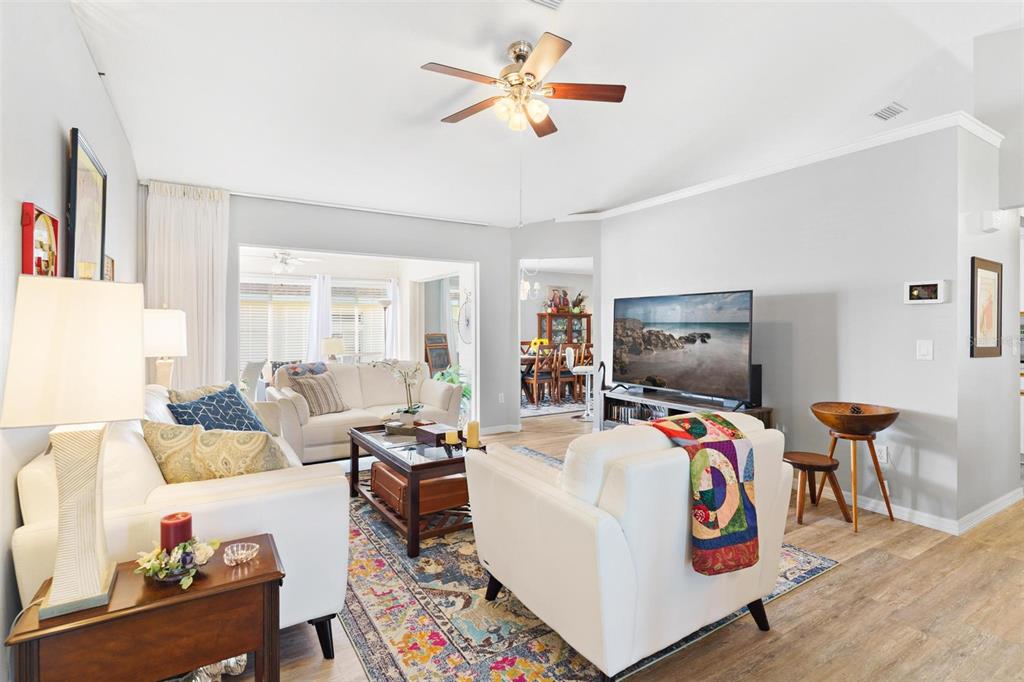 Formal Living Room features luxuary vinyl flooring while overlooking the Florida Room & Kitchen nook/dining area.