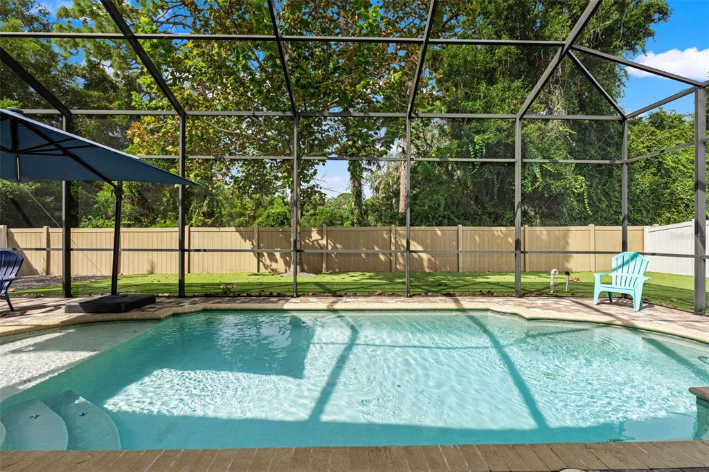 The screened saltwater pool is the centerpiece of this private backyard retreat, ready for sunny afternoons and weekend swims.