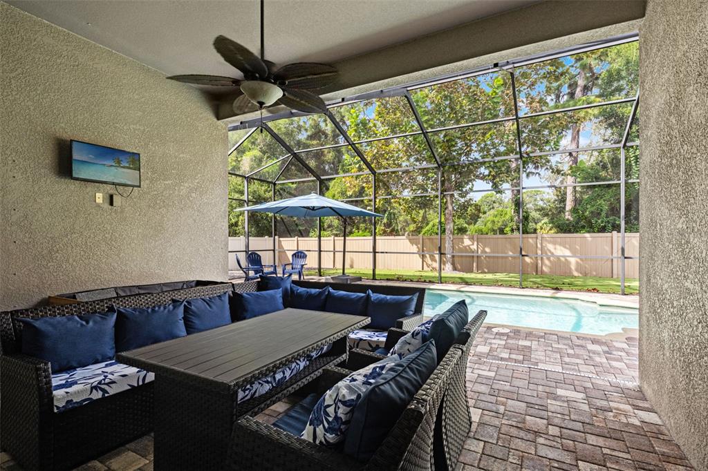 Welcome to the Florida room you’ll actually use—a covered outdoor living area overlooking the screened saltwater pool.