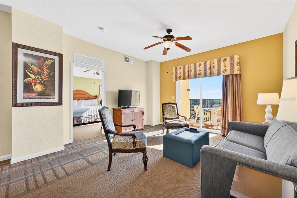 Natural light fills the living room, where sliding glass doors lead to a PRIVATE COVERED BALCONY.