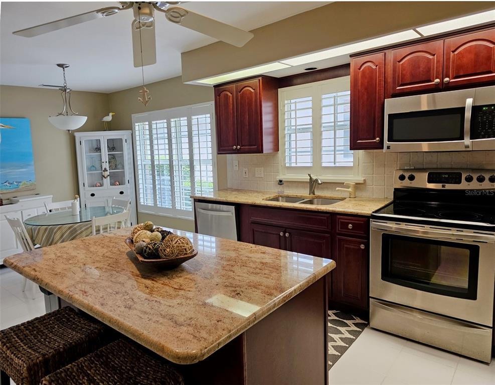 large eat-in-kitchen with ample granite countertops, center island and SS Appliances