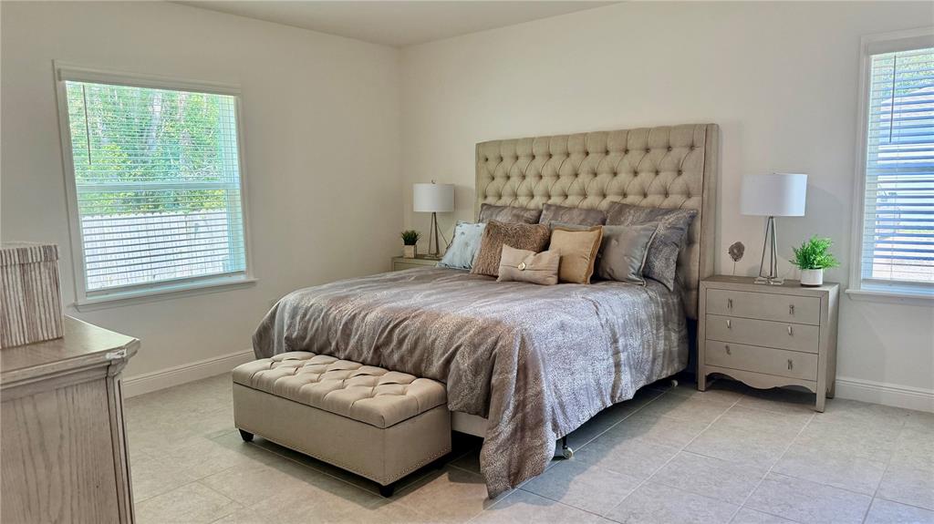 The primary suite offers a comfortable retreat with a tiled shower, dual vanities, and generous closet space.
