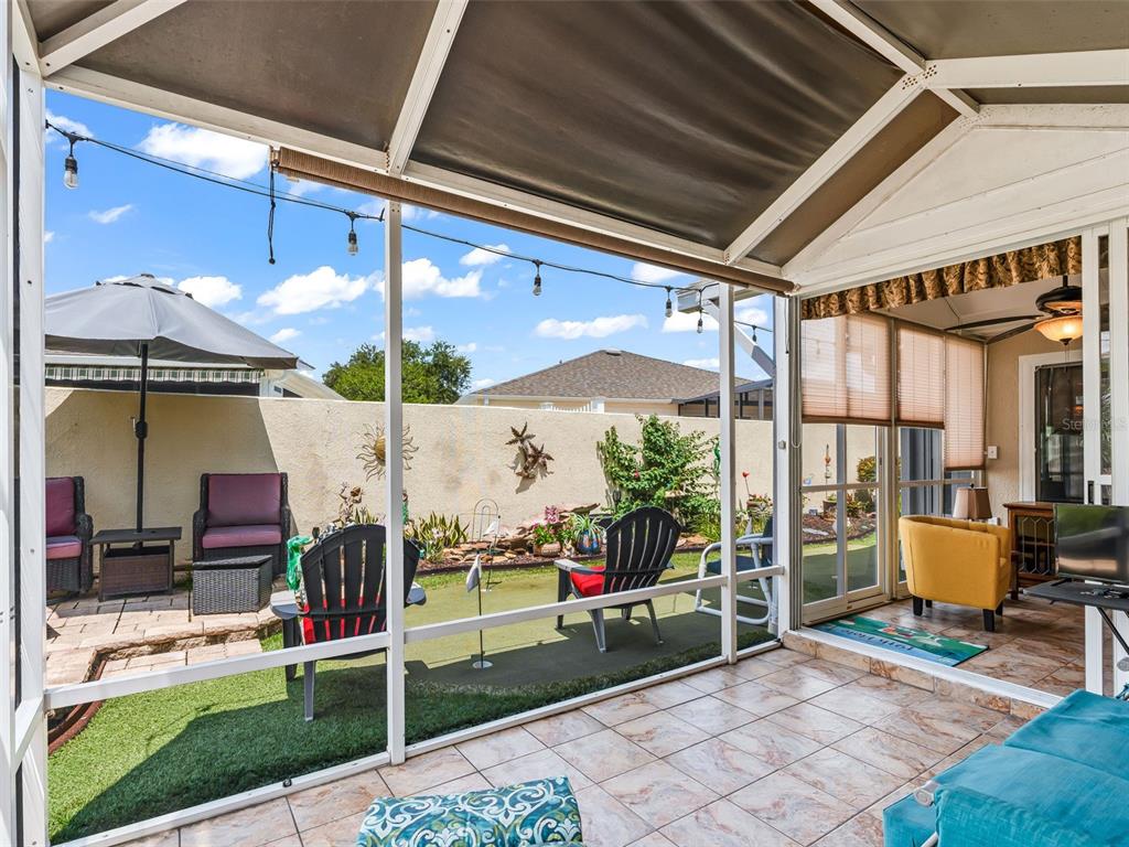 screen room looks out to back yard and putting green