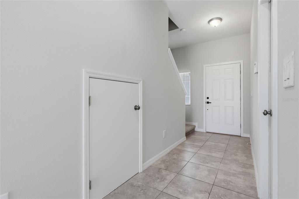 Open foyer with tile flooring and access to the stairs and main living area